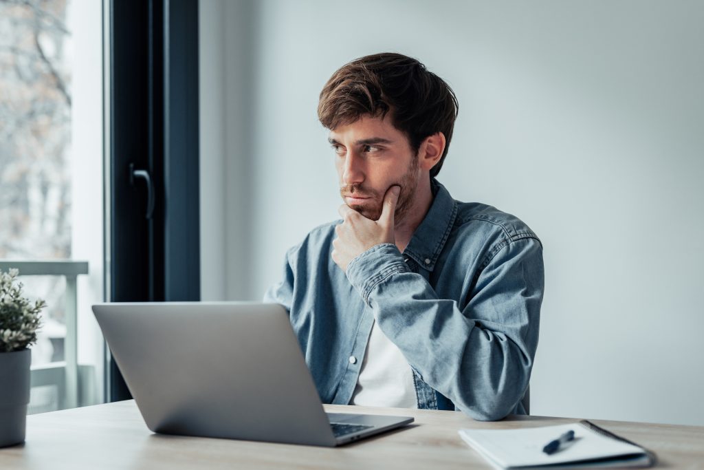 Man thinking how to start a private call during a main virtual meeting.
